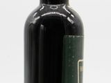 a black bottle with a green lid on a white surface