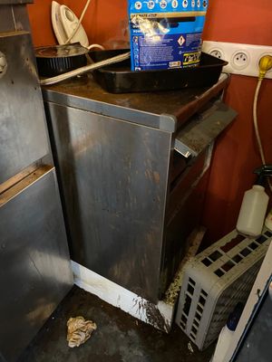 une photo d'une cuisine sale avec une cuisinière et un lave-vaisselle
