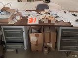 une table sur laquelle se trouvent de nombreuses boîtes et des papiers