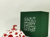 a red and white polka dot covered jar next to a green box