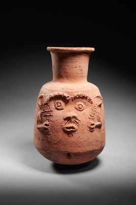 un gros plan d'un vase en argile orné d'un visage