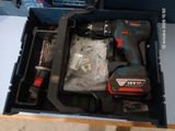 une boîte contenant une perceuse et d'autres outils
