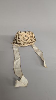a small hat with a ribbon around it on a table