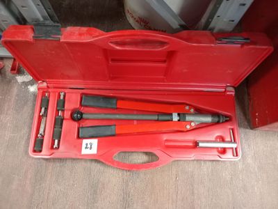 une caisse à outils rouge avec des outils sur le sol