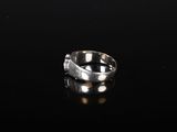 a close up of a silver ring on a black surface
