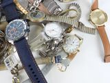 a pile of assorted watches and watches on a table