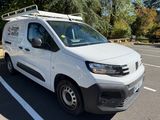 a white van parked in a parking lot with trees in the background
