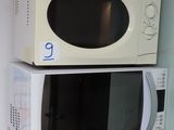 two microwaves stacked on top of each other on a shelf