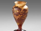 an old vase sitting on top of a table next to a white wall