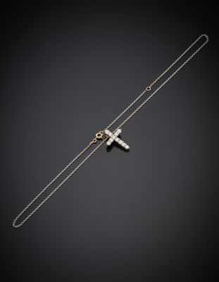une croix en argent suspendue à une chaîne sur fond noir