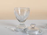 a glass bowl and a glass spoon sitting on a table