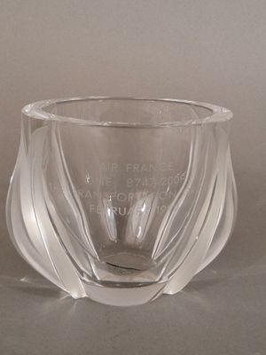 un vase en verre orné d'une citation, posé sur une table