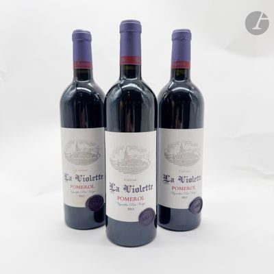 trois bouteilles de vin rouge posées sur une table blanche