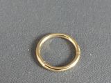 a close up of a gold ring on a gray surface