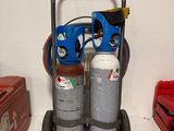 un chariot sur lequel sont posés deux bouteilles, à côté d'une boîte à outils