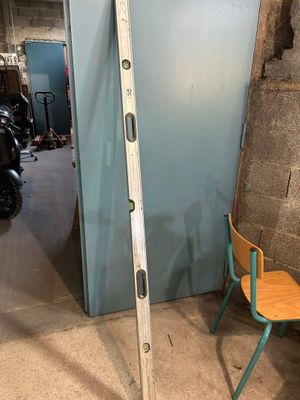 une échelle appuyée contre un mur, à côté d'une chaise