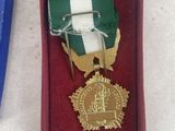 two medals in a red box on a white table