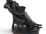 statue of a woman sitting in a chair with a fan