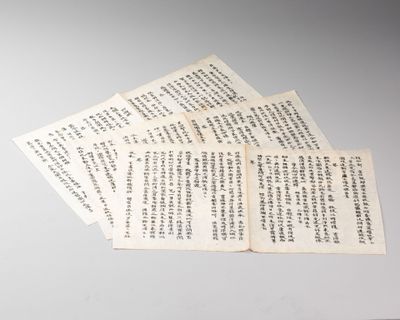 plusieurs feuilles de papier portant des inscriptions en chinois, posées sur une table