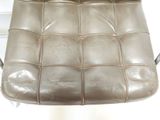 brown leather chair with chrome legs and a seat cushion