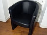 a black leather chair sitting in a corner of a room