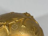 an image of a gold plate with a turtle on top of it