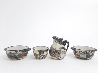 three small bowls and a pitcher sitting next to each other on a white surface
