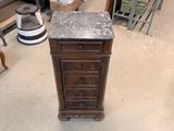 a wooden cabinet with a marble top in the middle of a room