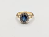 a gold ring with a blue stone surrounded by white diamonds