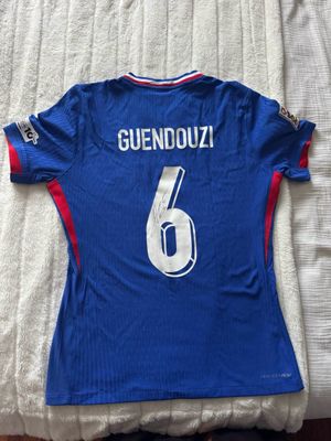 un gros plan sur un maillot de foot posé sur un lit