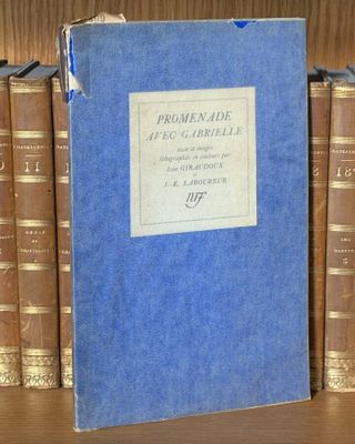 un livre posé sur une étagère où se trouvent de nombreux livres