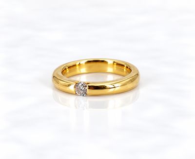une bague en or surmontée d'un seul diamant