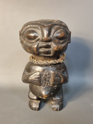 une petite figurine représentant un ours tenant un livre