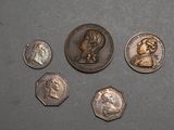four different coins are shown on a gray surface with a black background