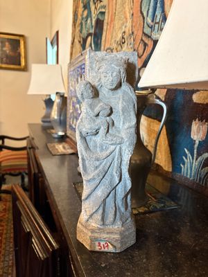 une statue de femme tenant un enfant sur une table