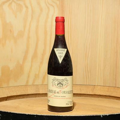 a bottle of wine sitting on top of a wooden barrel
