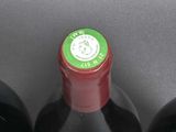 three bottles of red wine are lined up on a table