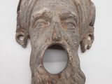 un gros plan sur une sculpture représentant le visage d'un homme sur une surface blanche