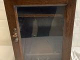 an old wooden cabinet with a glass door on a white background