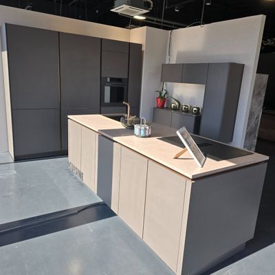 a kitchen with a laptop on the counter in the middle of the room