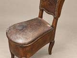 une vieille chaise en bois avec une assise en cuir sur fond gris