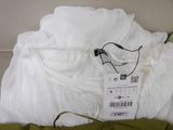 a bed with a white comforter and a green pillow