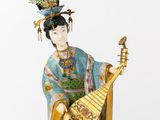 an oriental figurine of a woman playing a musical instrument