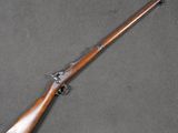 an old rifle with a wooden handle on a gray surface