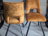 pair of mid century style chairs with leather upholstered seats and metal legs