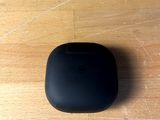 a black apple airpods sitting on a wooden table