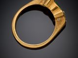 a close up of a gold ring with a green stone