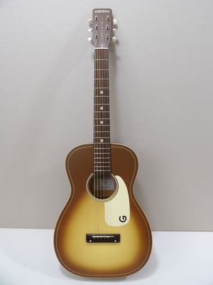 une guitare acoustique posée sur une table blanche