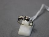 une photo d'une bague en diamant posée sur un bloc de marbre blanc
