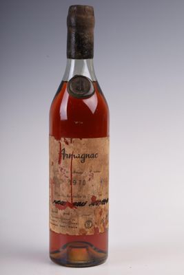 an old bottle of alcohol sitting on top of a white surface